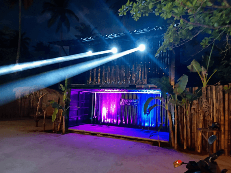 14R moving head beam lights producing sharp white beams, purple and blue par washes below